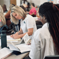 star in person training white woman black woman writing