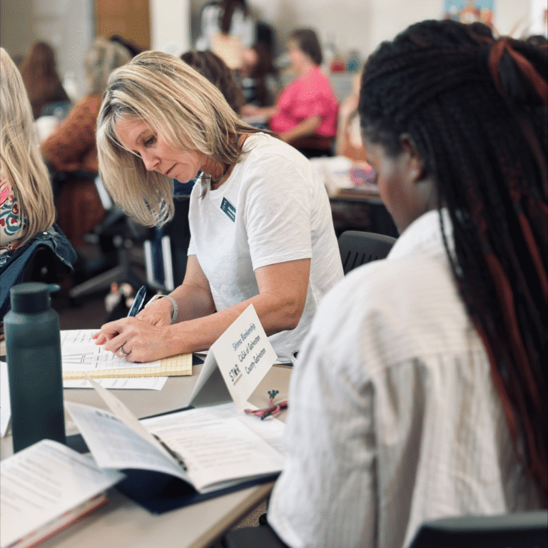 star in person training white woman black woman writing